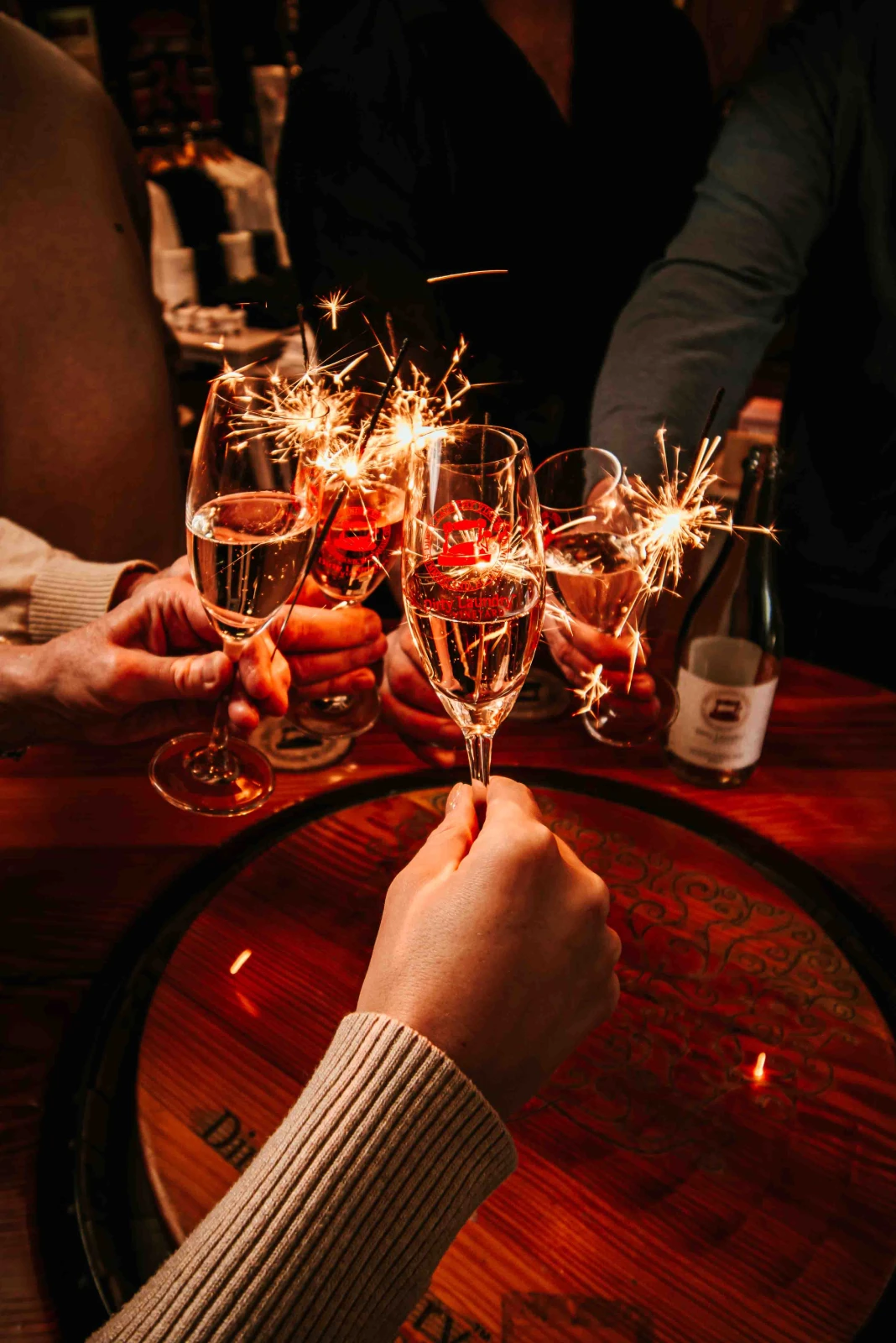 A group holding glasses of wine and sparklers
